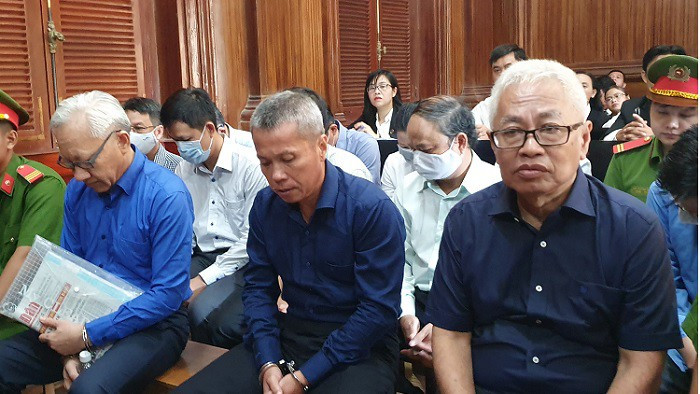 Ông Phùng Ngọc Khánh (bìa trái) xuất hiện cùng ông Trần Phương Bình (bìa phải) tại tòa trong vụ đại án DAB.