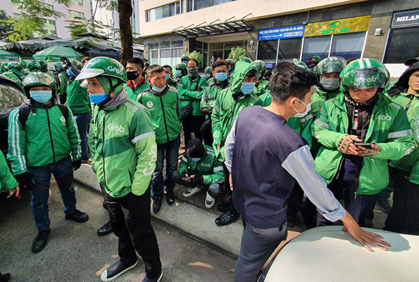 Các tài xế Grab tụ tập phản đối trước trụ sở của hãng tại Hà Nội