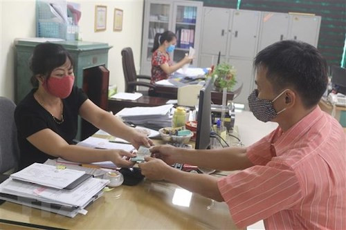 Anh Nguyễn Minh Tuân, nhân viên khách sạn Hải Yến ( TP Cẩm Phả, Quảng Ninh) được nhận 3 tháng lương do đơn vị chi trả từ gói cho vay trả lương ngừng việc. Ảnh: TTXVN